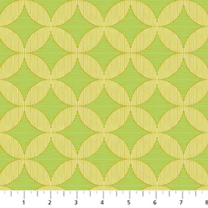 Fabric with geometric pattern on a green background, measured with a ruler at the bottom.