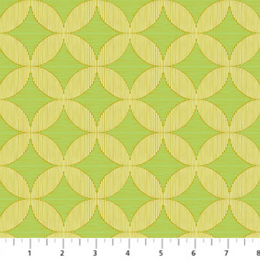 Fabric with geometric pattern on a green background, measured with a ruler at the bottom.