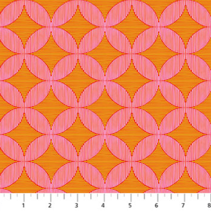 Pink geometric pattern on orange fabric with a ruler at the bottom