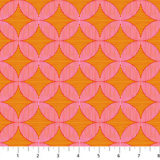 Pink geometric pattern on orange fabric with a ruler at the bottom